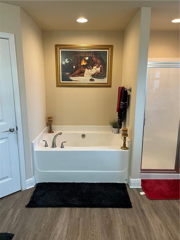 bathroom with wood-type flooring and separate shower and tub