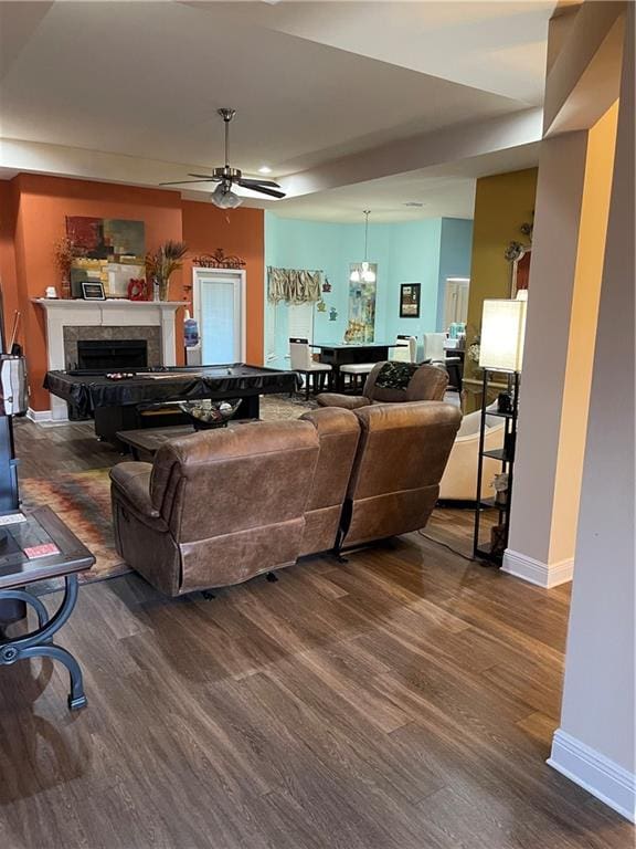 living room with ceiling fan with notable chandelier and hardwood / wood-style flooring