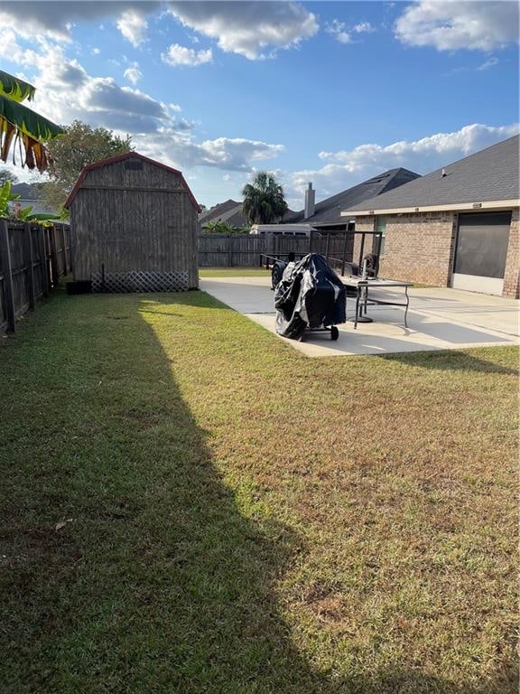 view of yard with a shed and a patio area