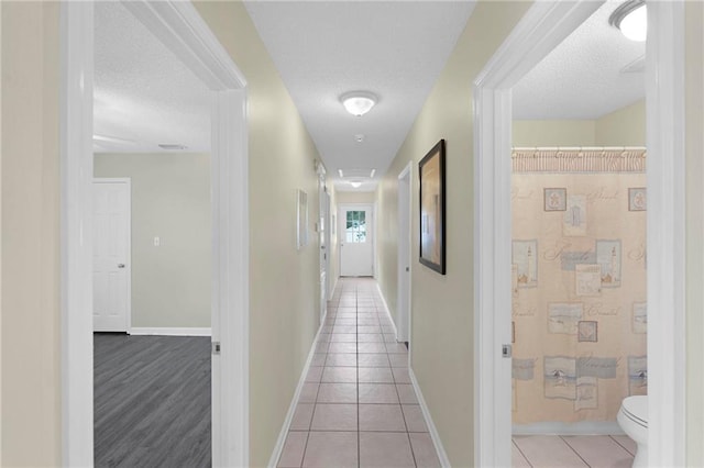 hall featuring a textured ceiling and light wood-type flooring