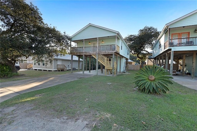 beach home featuring covered porch and a front lawn