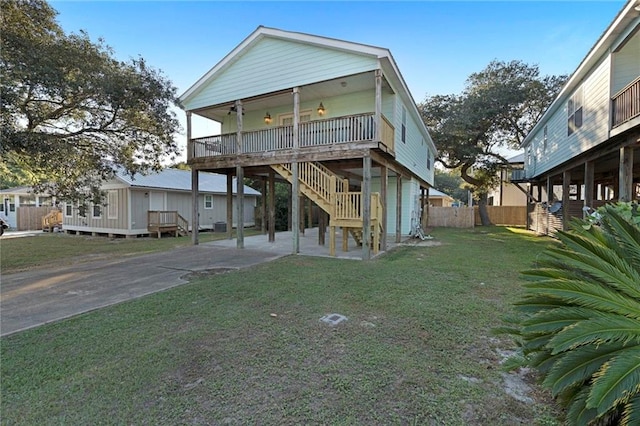 view of front of property with a wooden deck, a patio, and a front yard