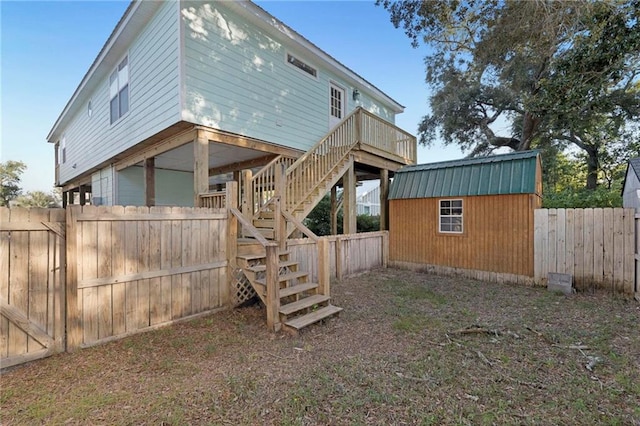 back of house featuring a storage shed and a wooden deck