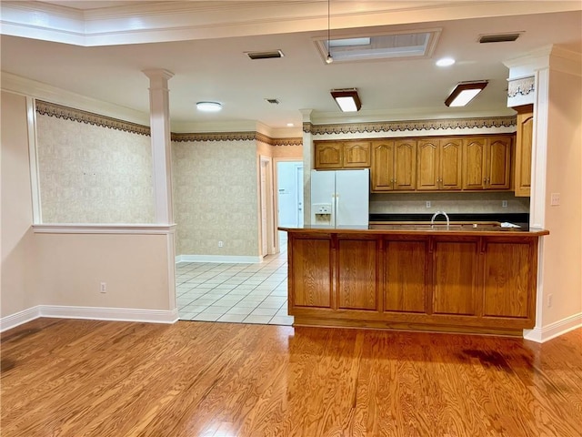 734 Natchez Trail Ct, Mobile, AL 36609 - kitchen featuring brown cabinetry, crown molding, decorative columns, visible vents, and white refrigerator with ice dispenser