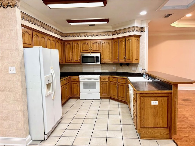 734 Natchez Trail Ct, Mobile, AL 36609 - kitchen featuring brown cabinetry, a peninsula, dark countertops, white appliances, and a sink