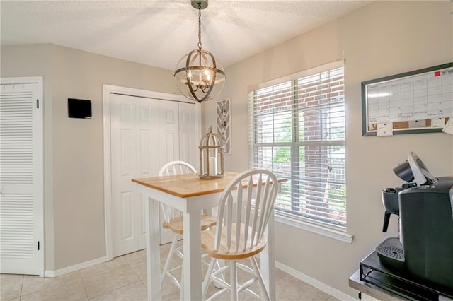 dining space with a notable chandelier, a textured ceiling, light tile patterned floors, and a wealth of natural light