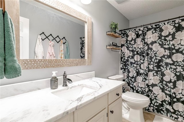 bathroom with tile patterned floors, a textured ceiling, vanity, and toilet