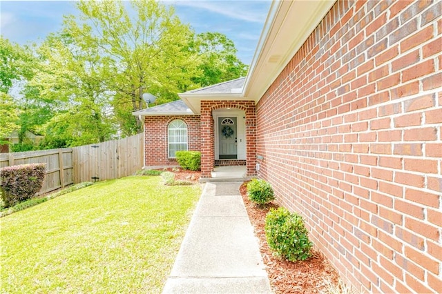 view of exterior entry featuring a yard