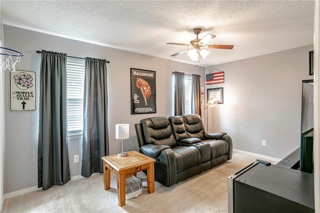 carpeted living room featuring ceiling fan and a textured ceiling