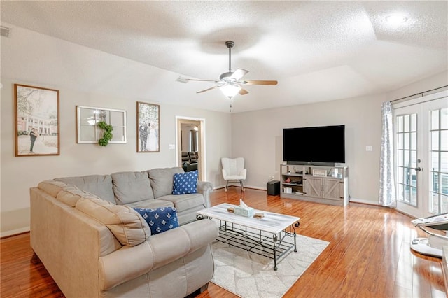 living room with ceiling fan, hardwood / wood-style flooring, and a textured ceiling