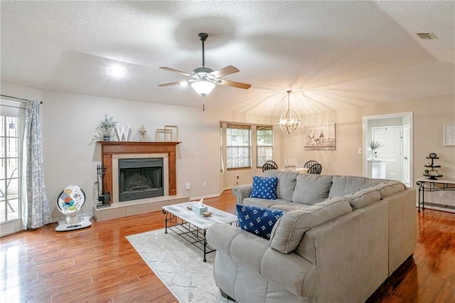 living room featuring a textured ceiling, a fireplace, and hardwood / wood-style floors