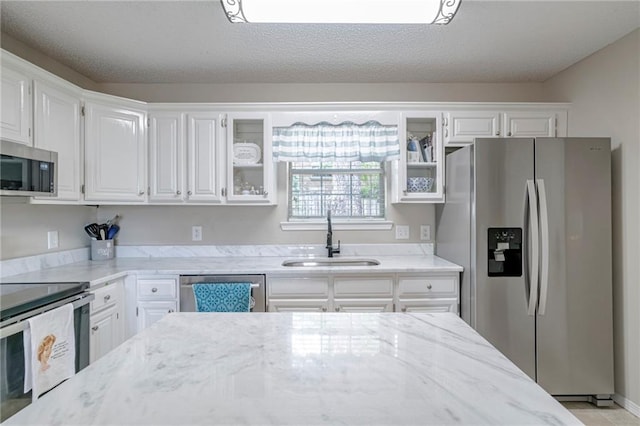 kitchen featuring white cabinets, appliances with stainless steel finishes, and sink