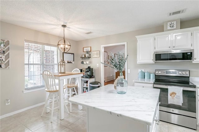 kitchen featuring white cabinets, hanging light fixtures, a kitchen island, a chandelier, and appliances with stainless steel finishes