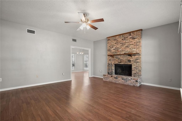 unfurnished living room featuring a textured ceiling, dark wood-type flooring, a fireplace, and visible vents