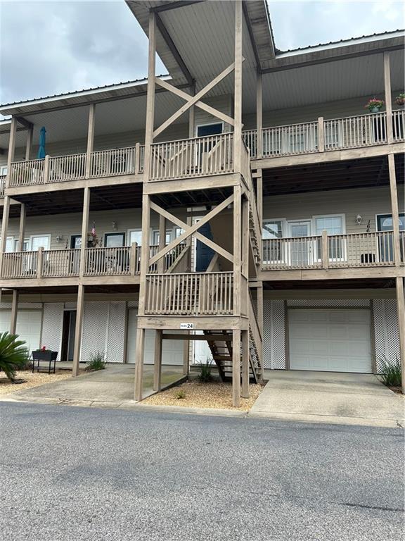 view of property featuring stairway, an attached garage, and driveway