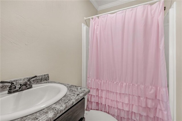 bathroom featuring vanity, crown molding, and toilet