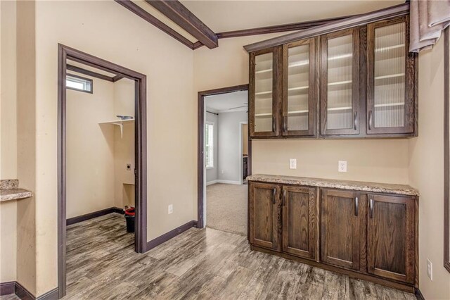 kitchen featuring ceiling fan, black appliances, hardwood / wood-style floors, and beam ceiling