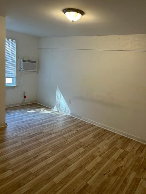 empty room with a wall unit AC and wood finished floors