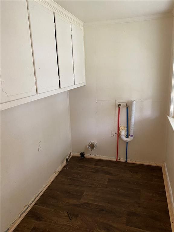 clothes washing area with cabinet space, crown molding, and wood finished floors