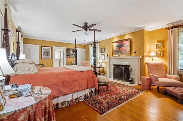 bedroom featuring hardwood / wood-style flooring, ornamental molding, and ceiling fan