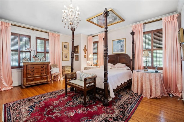 bedroom with hardwood / wood-style floors, ornamental molding, and multiple windows