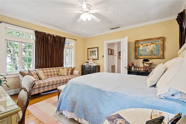 bedroom featuring ceiling fan, light wood-type flooring, and ornamental molding