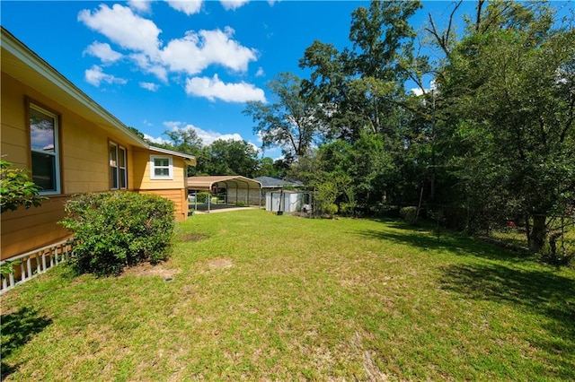 view of yard featuring a storage unit and a carport