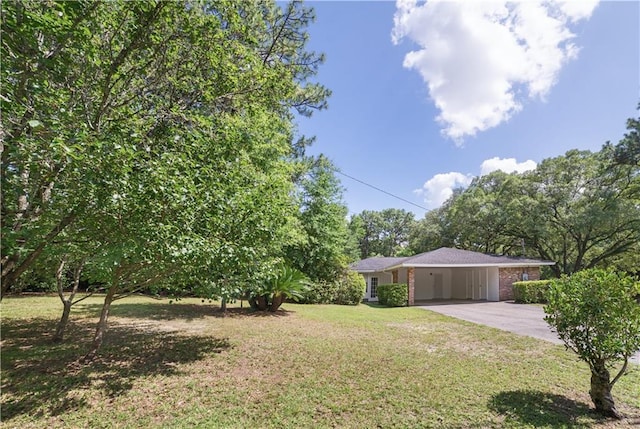 1008 Chalet Dr W, Mobile, AL 36608 - view of green lawn featuring driveway and an attached carport