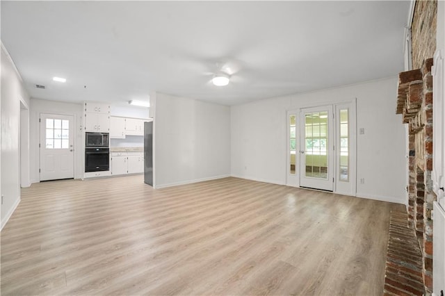 1008 Chalet Dr W, Mobile, AL 36608 - unfurnished living room with light wood-type flooring, a brick fireplace, and ceiling fan