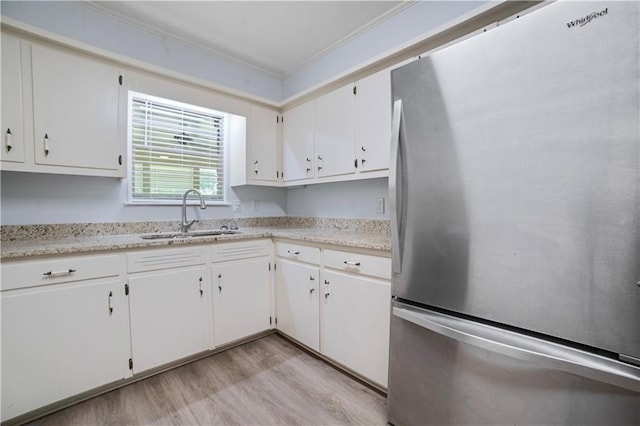 1008 Chalet Dr W, Mobile, AL 36608 - kitchen with freestanding refrigerator, ornamental molding, light wood-style flooring, and white cabinetry