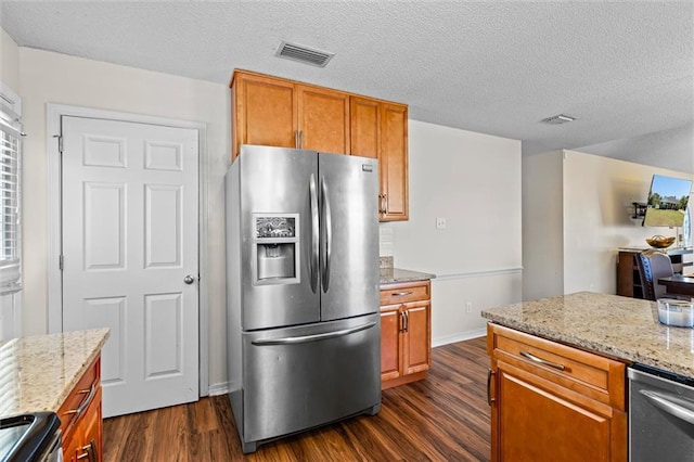 kitchen with light stone counters, stainless steel appliances, and dark hardwood / wood-style floors