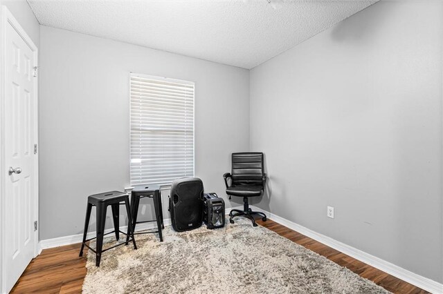 living area with a textured ceiling and hardwood / wood-style flooring