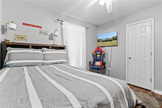 bedroom with ceiling fan, hardwood / wood-style flooring, and a textured ceiling