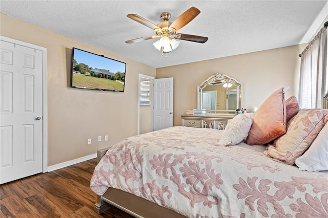 bedroom featuring ceiling fan, a textured ceiling, and dark hardwood / wood-style flooring