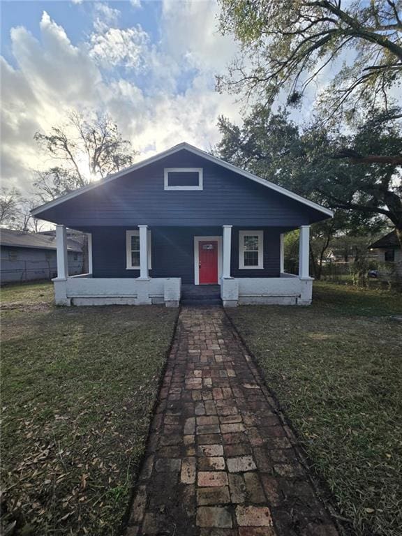 bungalow-style house with a porch and a front lawn