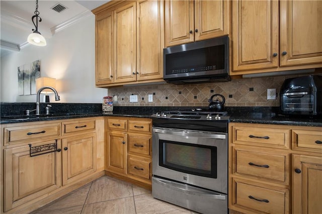 kitchen featuring dark stone countertops, hanging light fixtures, stainless steel appliances, and ornamental molding