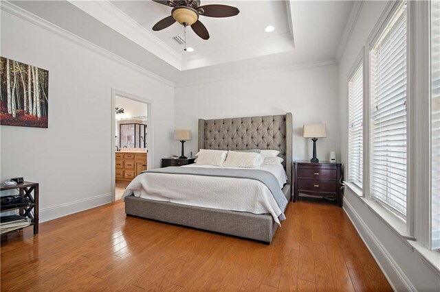 bedroom with multiple windows, ceiling fan, and hardwood / wood-style floors