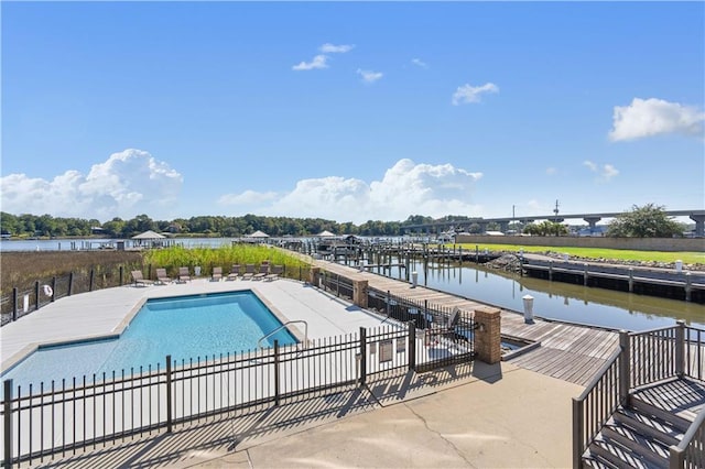 view of pool featuring a water view and a patio