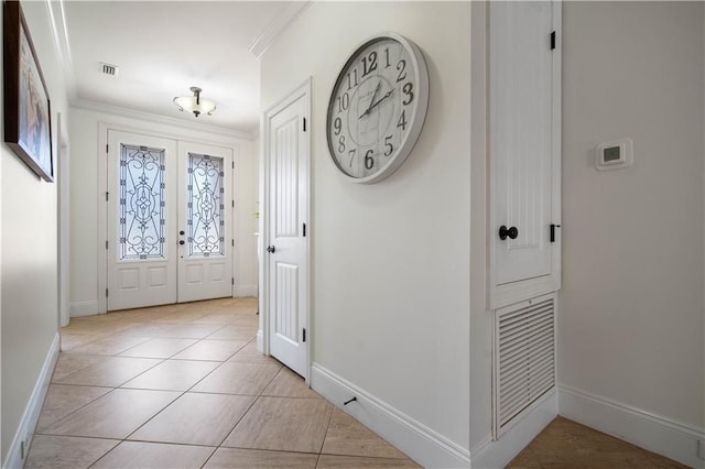 entrance foyer with crown molding, french doors, and light tile patterned flooring