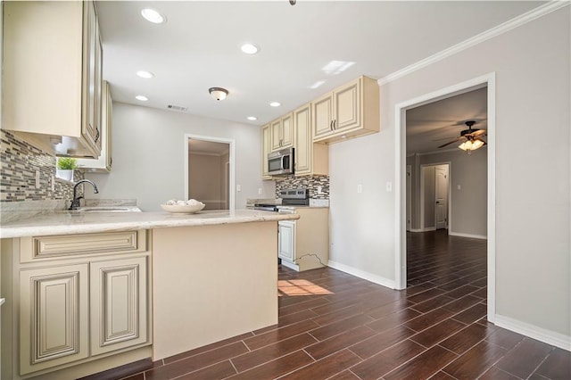 kitchen featuring cream cabinetry, dark wood-type flooring, sink, stainless steel appliances, and backsplash