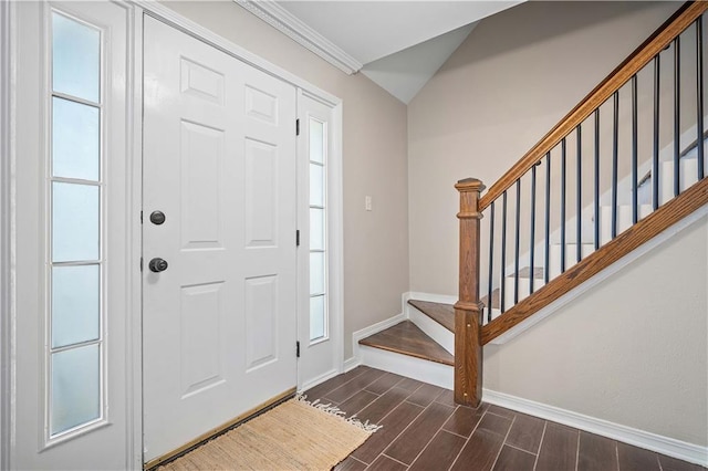 entrance foyer with dark hardwood / wood-style floors, crown molding, and vaulted ceiling