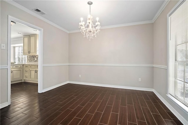 spare room with an inviting chandelier, crown molding, and dark hardwood / wood-style flooring