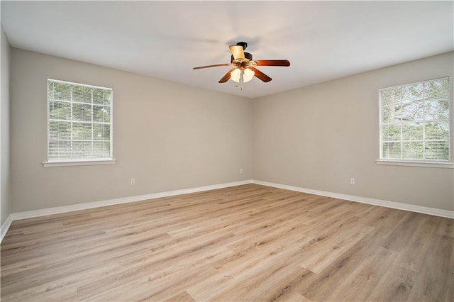 spare room with ceiling fan, light wood-type flooring, and a healthy amount of sunlight