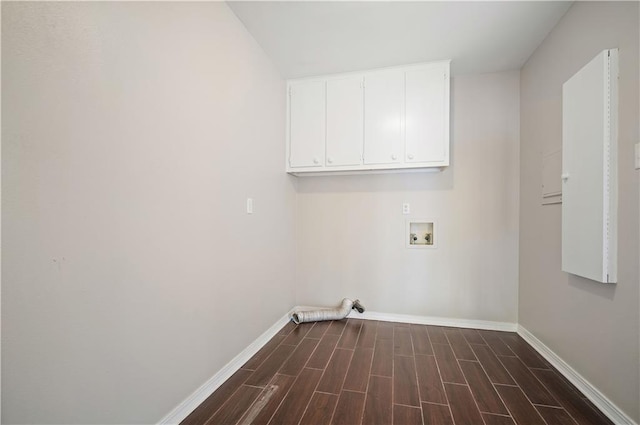 washroom with washer hookup, dark hardwood / wood-style floors, and cabinets