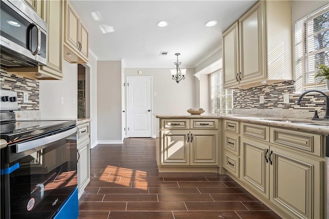 kitchen with plenty of natural light, white range oven, and cream cabinetry