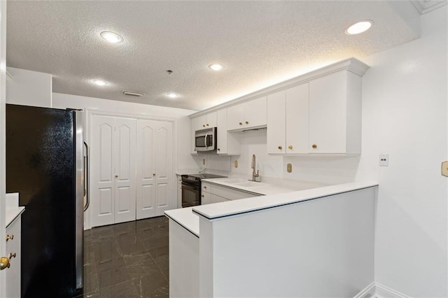 kitchen featuring a peninsula, a sink, white cabinets, marble finish floor, and appliances with stainless steel finishes