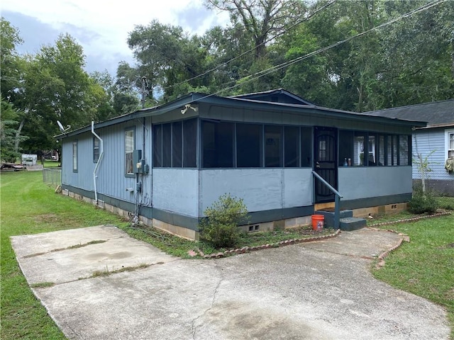 view of front of house with a front lawn and a sunroom