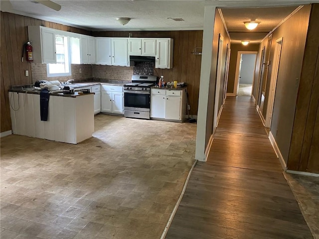 kitchen featuring gas range, white cabinetry, and crown molding