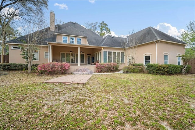 6721 Stonebrook Dr N, Mobile, AL 36695 - rear view of house with ceiling fan, stucco siding, a chimney, a lawn, and a patio area