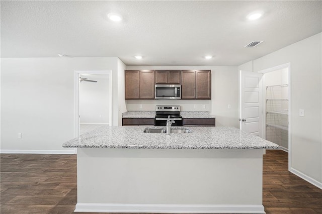 10529 Wales Ln, Spanish Fort, AL 36527 - kitchen with stainless steel appliances, dark wood finished floors, a kitchen island with sink, light stone counters, and recessed lighting